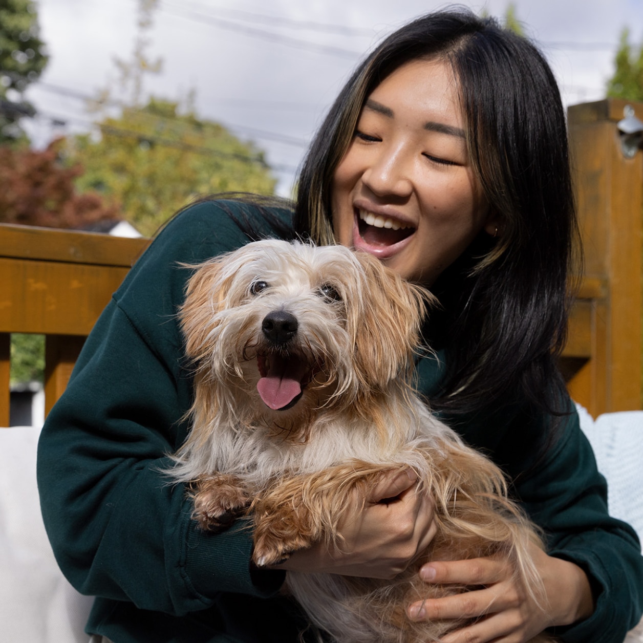 Femme tenant un petit chien heureux dans ses bras