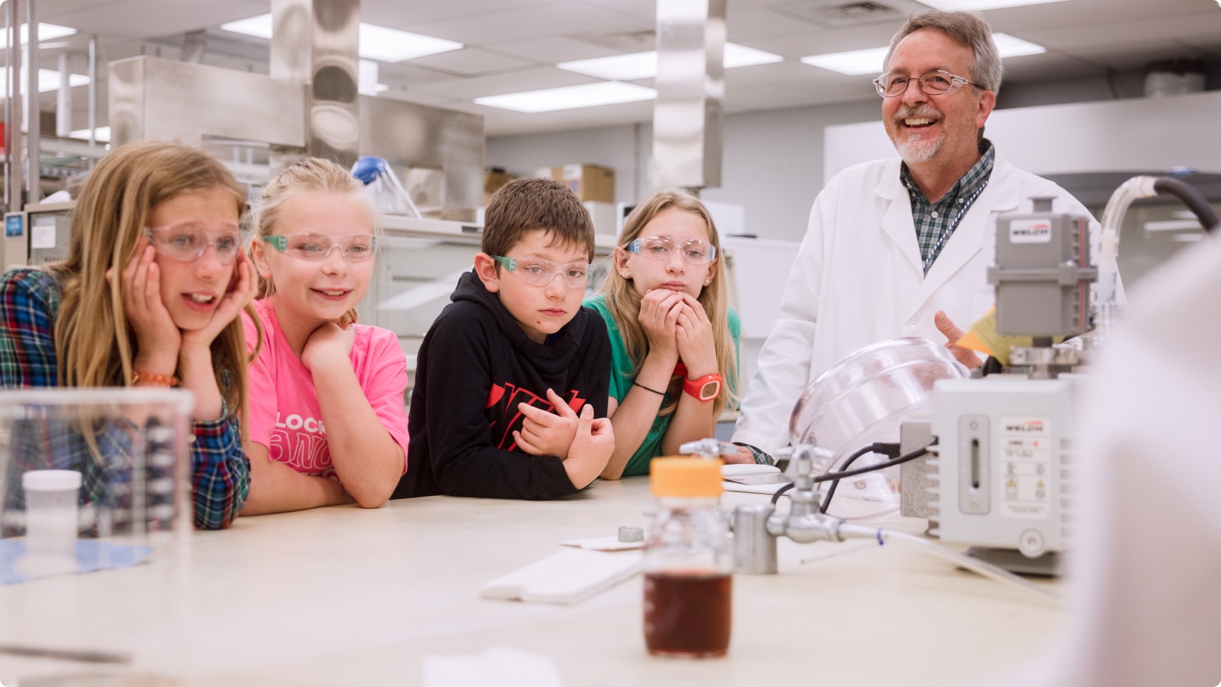 Membre de l’équipe de recherche du Centre mondial de nutrition animale montrant le laboratoire de recherche à un groupe d’enfants