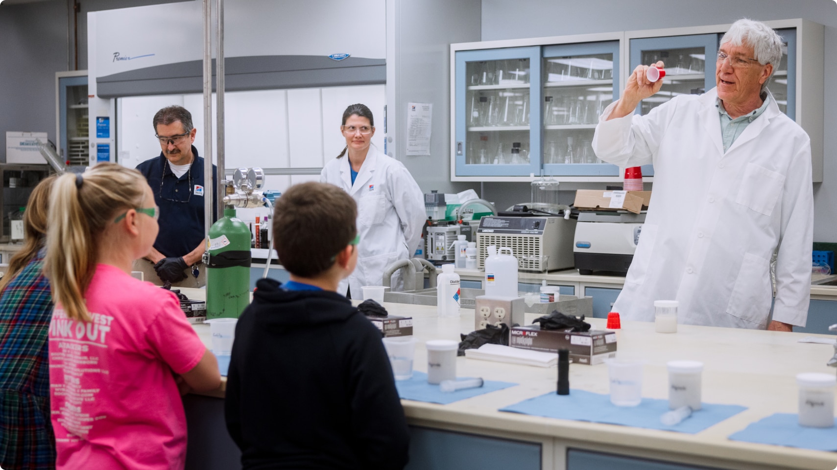 Membre de l’équipe de recherche du Centre mondial de nutrition animale montrant le laboratoire de recherche à un groupe d’enfants