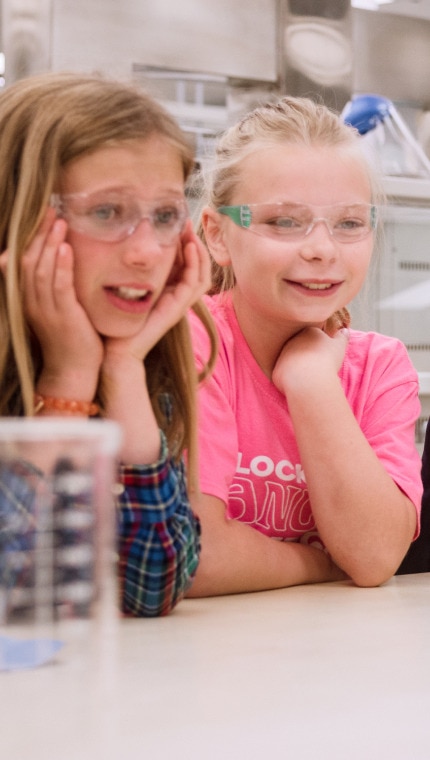 Membre de l’équipe de recherche du Centre mondial de nutrition animale montrant le laboratoire de recherche à un groupe d’enfants