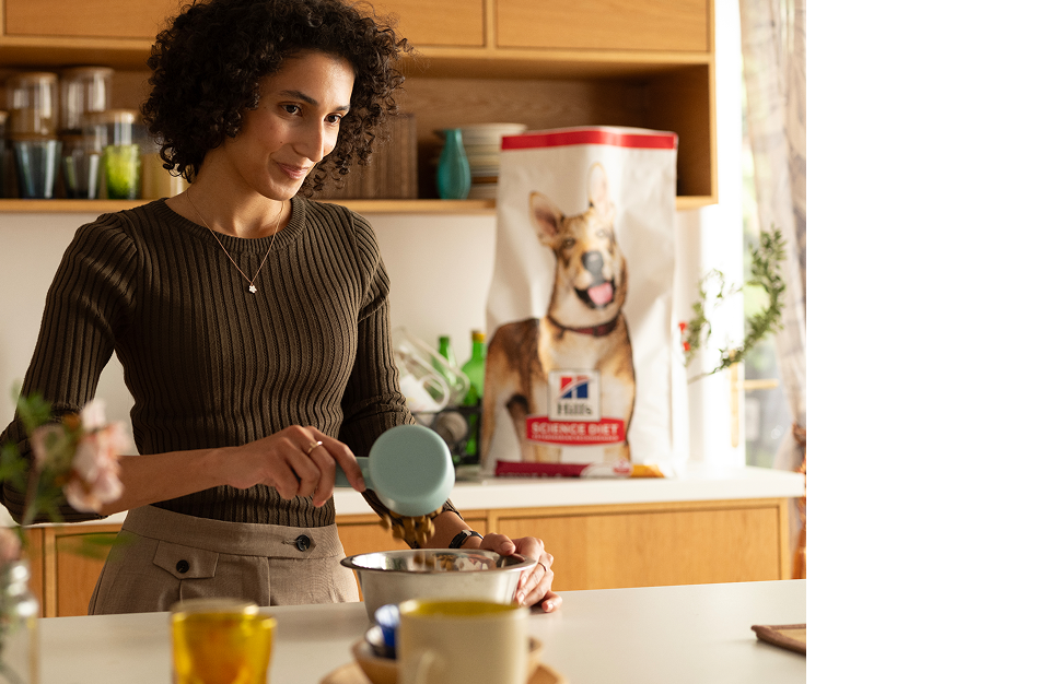 Une femme sert de la nourriture Hill’s dans un bol